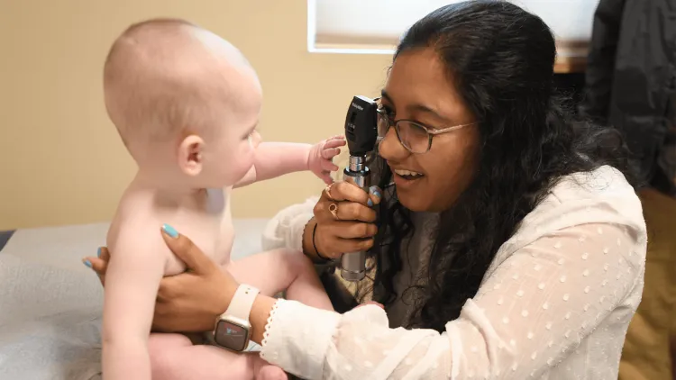 a person examining a baby