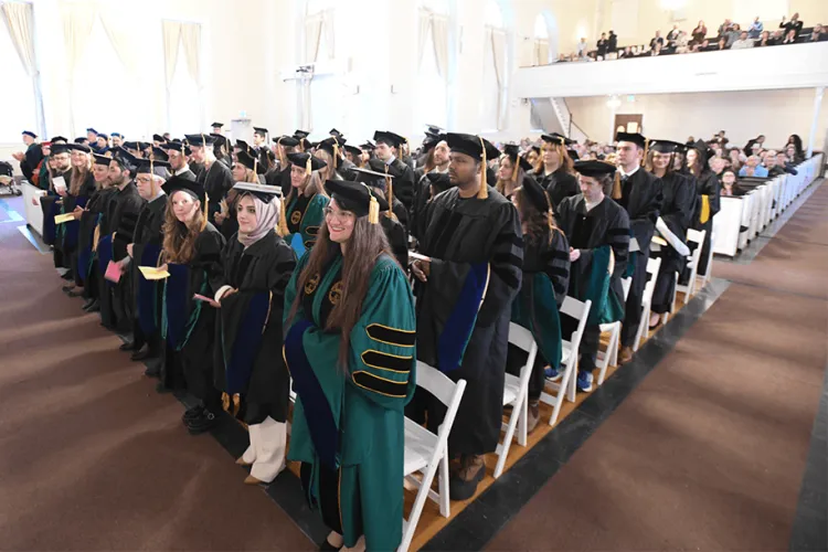 students in academic regalia at a graduation ceremony