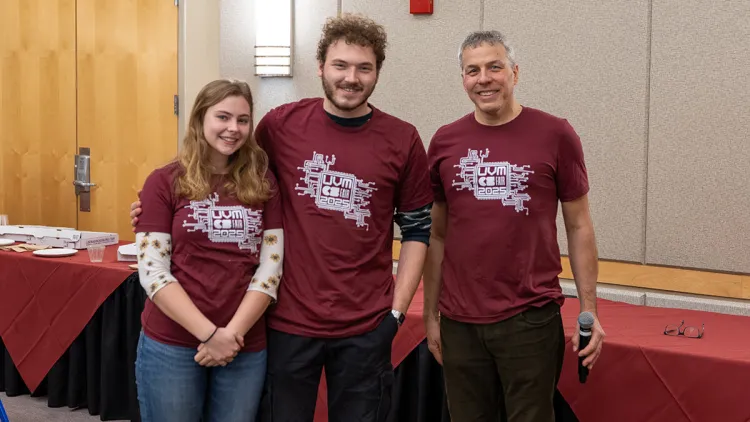 Two students pose with a faculty member