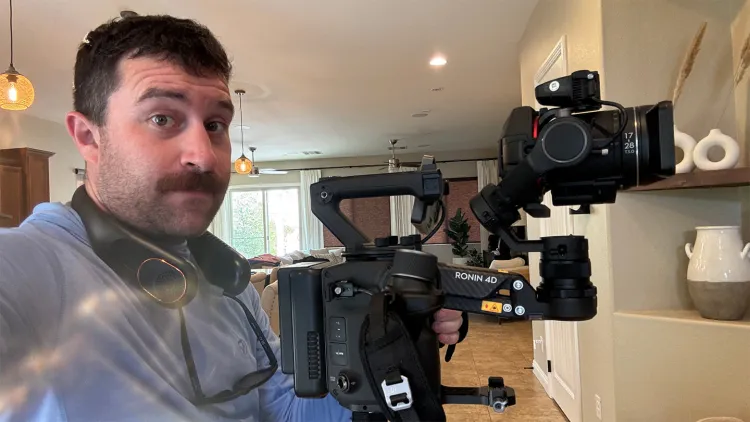 Person holding a professional camera rig inside a home.