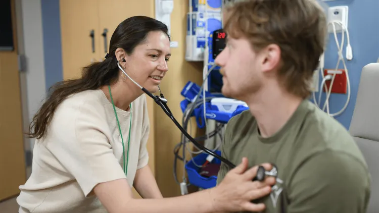 a person listening to another person's chest with a stethoscope