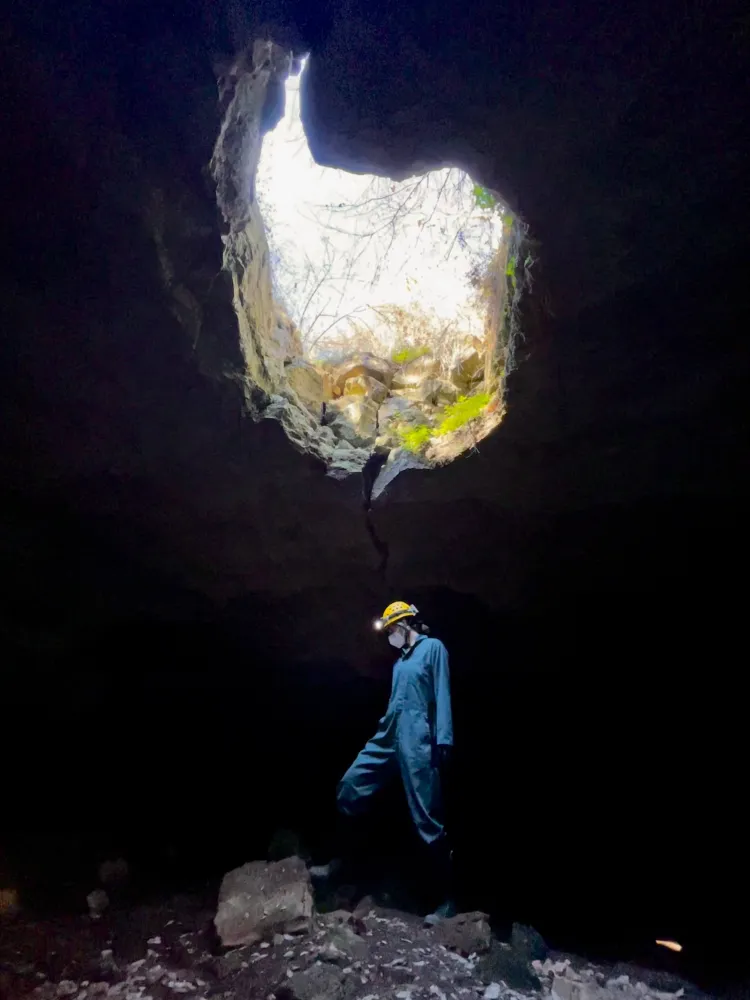 A person stands in a cave.
