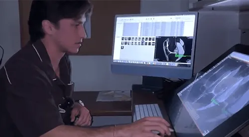 a person looking at 2 computer screens