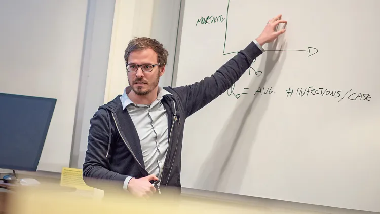 Professor teaching at a white board
