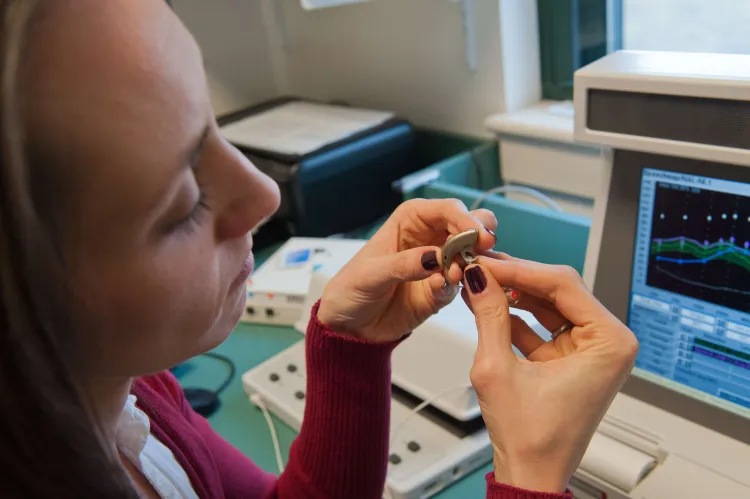 Professor looking at hearing aid