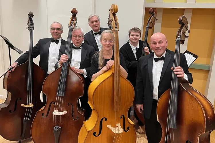 a group of double bass players with their instruments