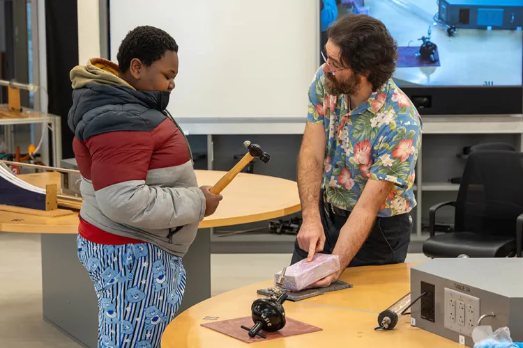 A physics professor shares a demonstration with middler school students