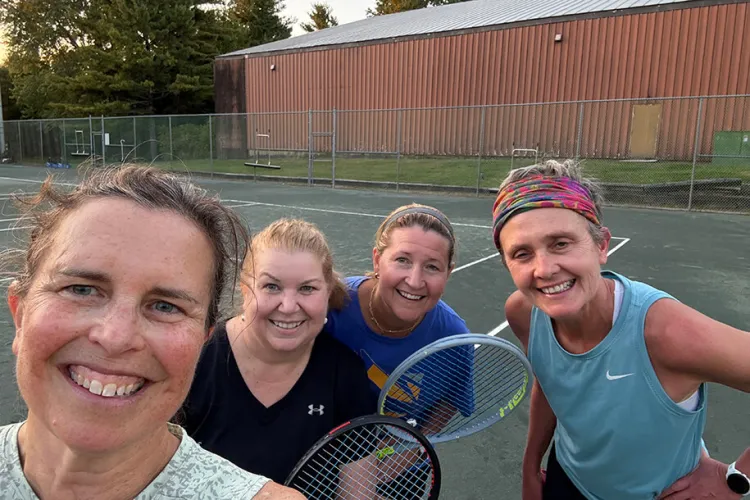 four tennis players smile after a game