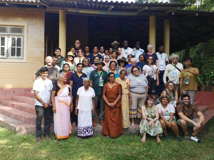 Folks stand in a group in front of a building under an awning.