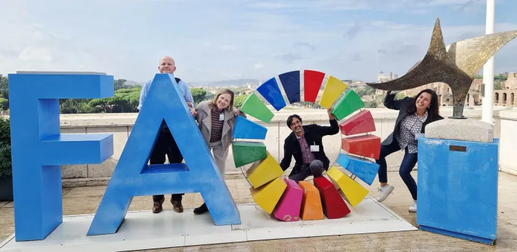 Members of the IFA team pose with an FAO art installment in Rome.