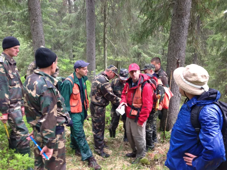 A group of people stands in the forest. 