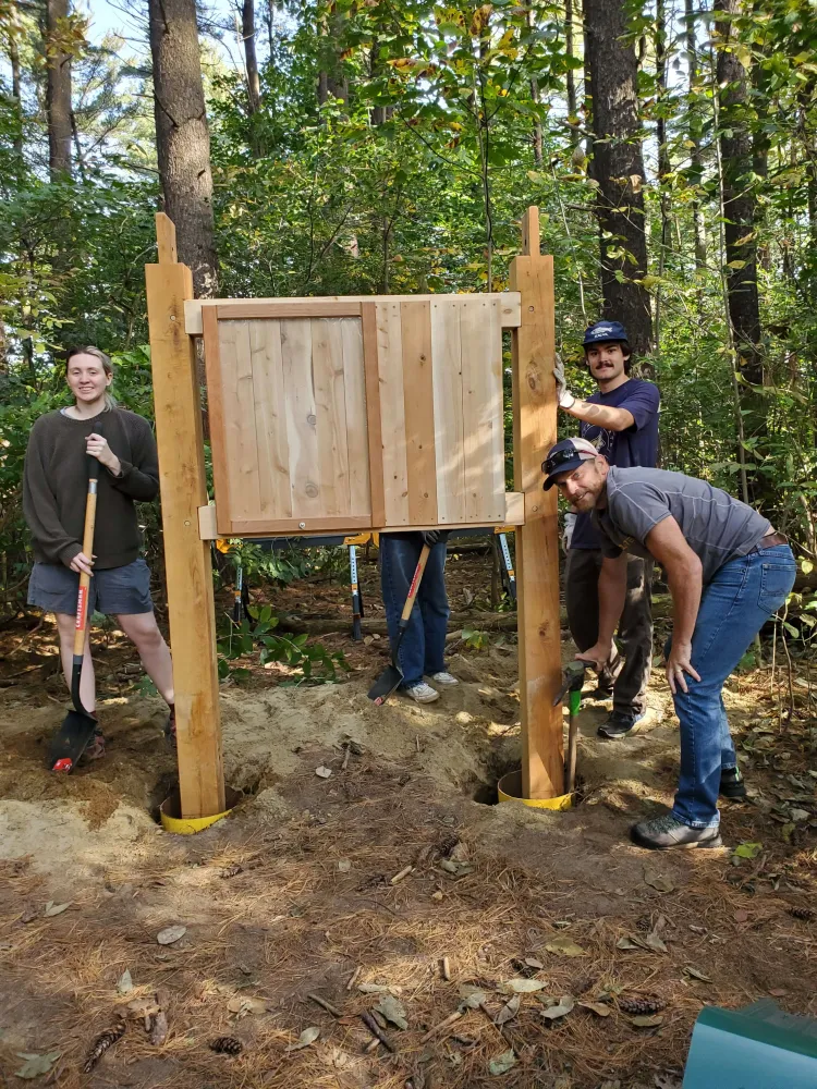 Employees installing a kiosk at East Woods