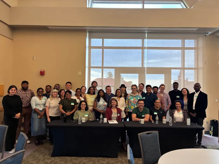 A group of postdoctoral scholars posing in front of a table.