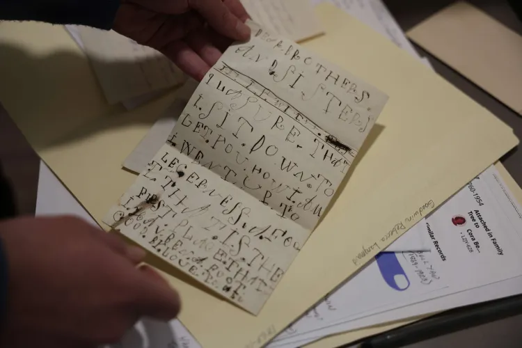 Hands are holding a small letter with large, looping text.