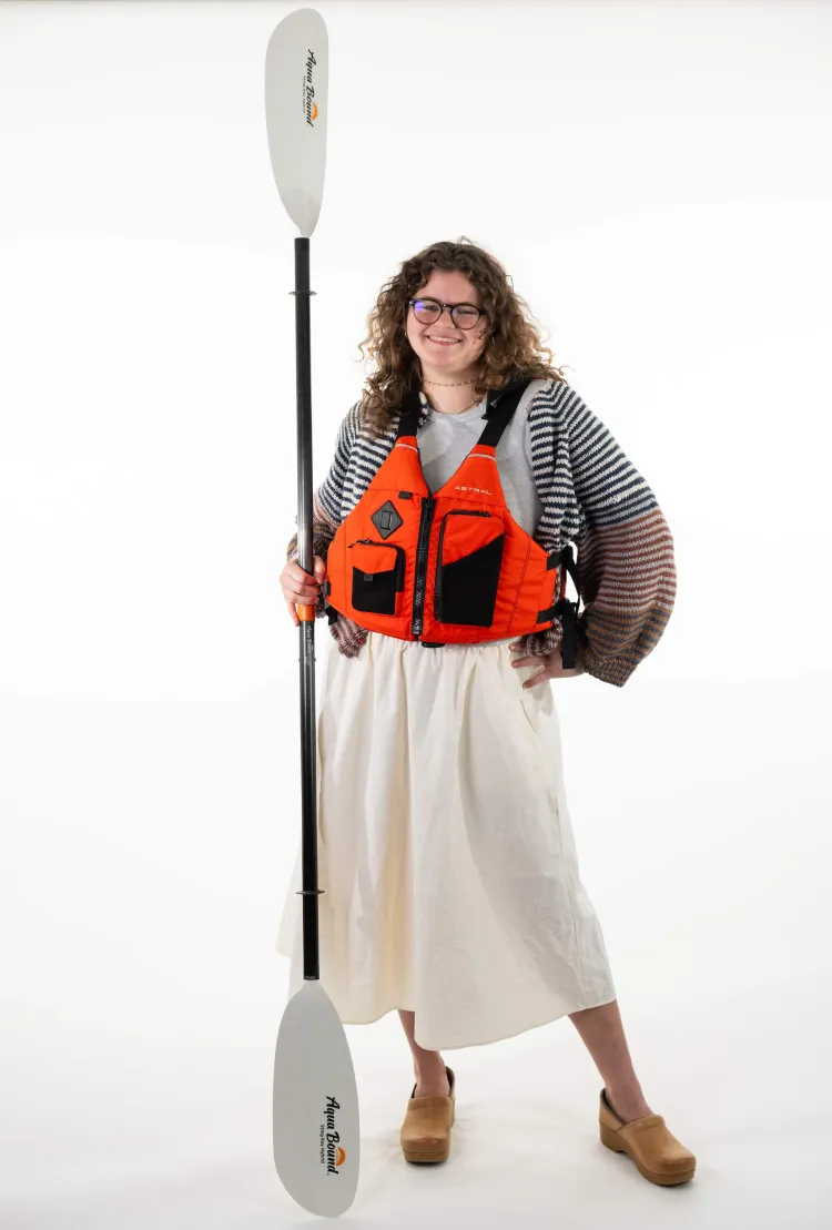 Woman standing with kayak paddle