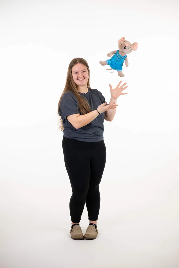 woman tossing a stuffie in the air