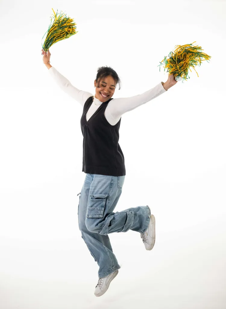 woman jumping with pom poms