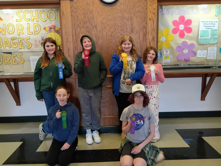 Six kids hold up ribbons.