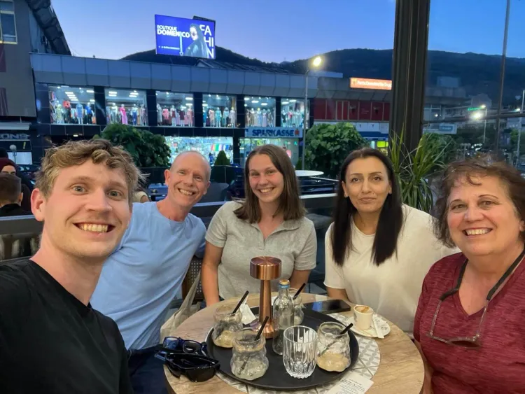 People sitting around an outdoor table at a restaurant