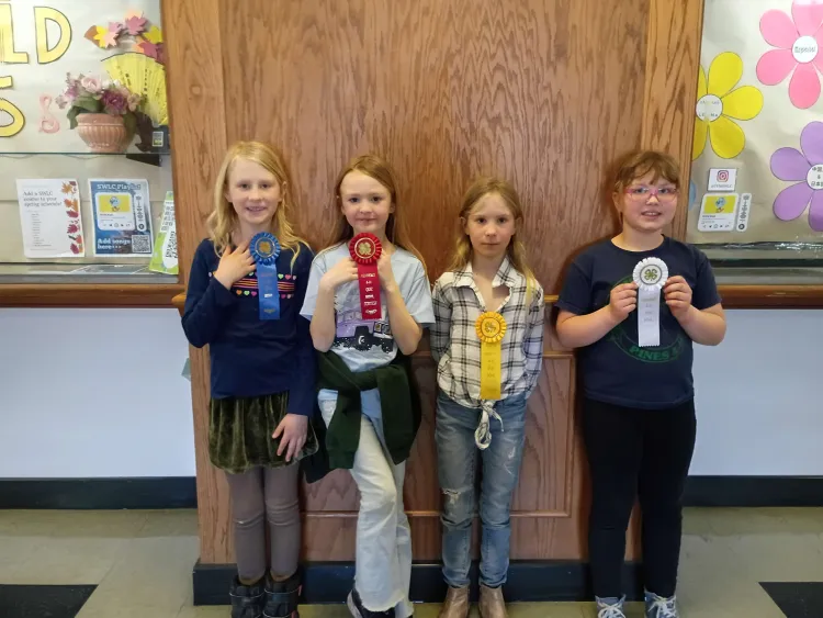 Four kids hold up ribbons