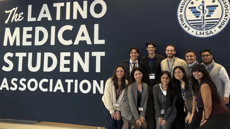 a group of people at a conference in front of a banner