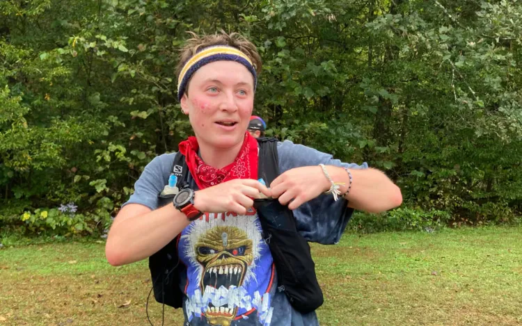 person in sports running gear resting for a moment in a wooded area