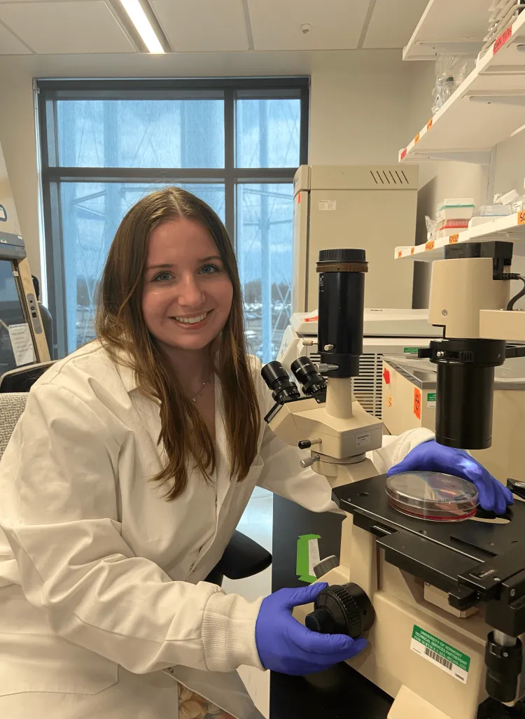 Woman working in a genetics lab smiling