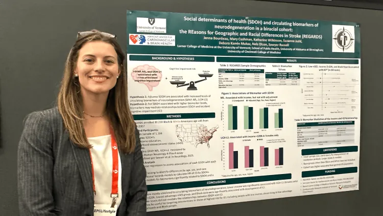 Person smiling in front of a post of her scientific study. 