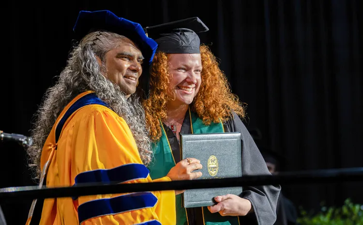 Dean Dewoolkar presents a diploma to a graduating CEMS student