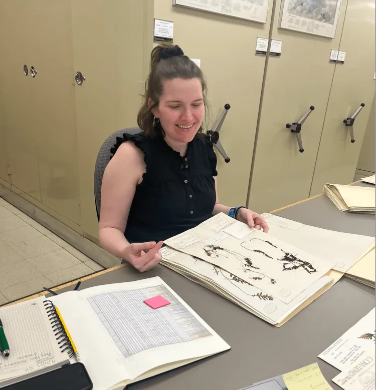 Woman in a Herbarium looking at fern specimens