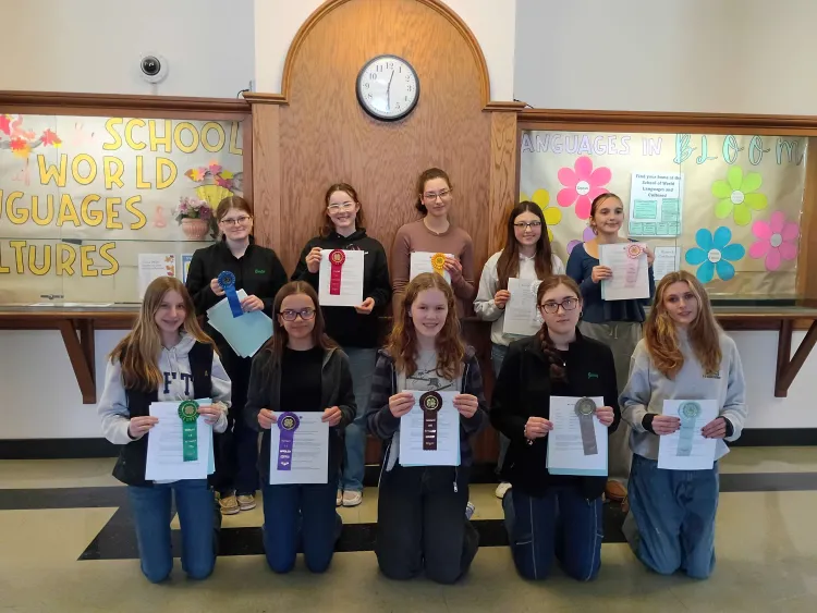 Ten young people with ribbons and papers