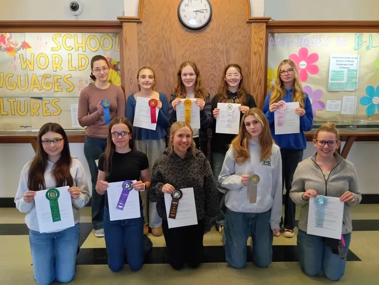 10 teenagers holding ribbons and papers