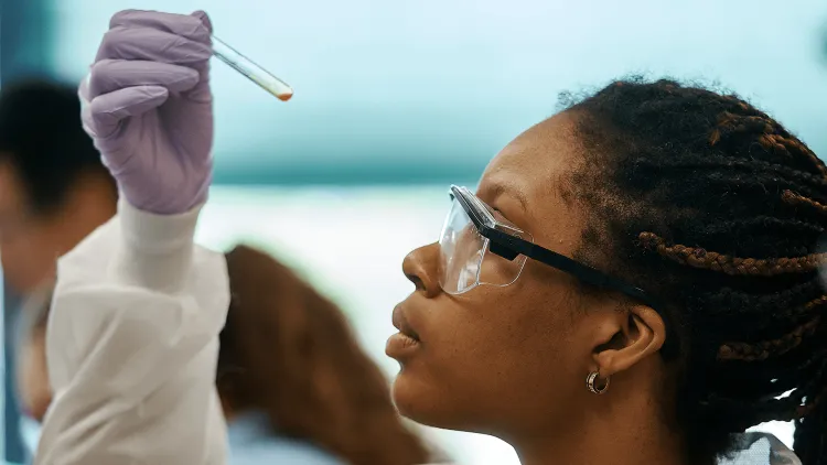 a person looking at a test tube