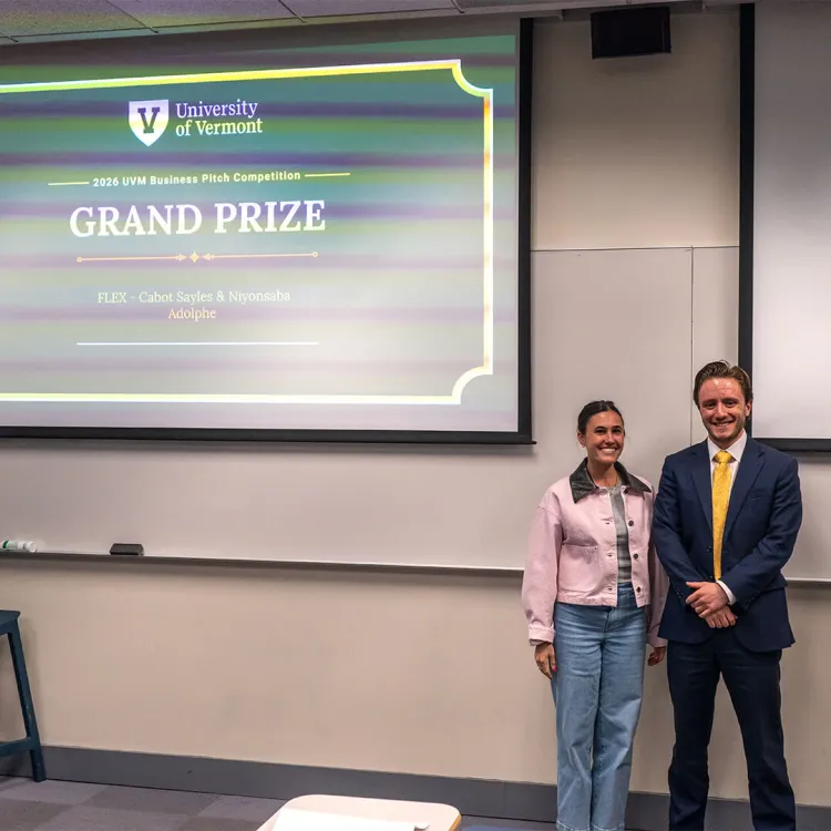 UVM student stands in front of a projected screen declaring him the grand prize winner