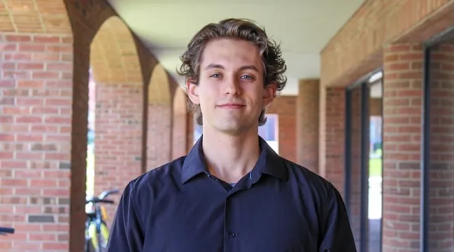 portrait of a man standing in front of a brick building