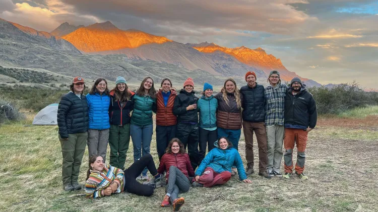 Alannah and her colleagues standing in front of the Montana mountains at sunset.