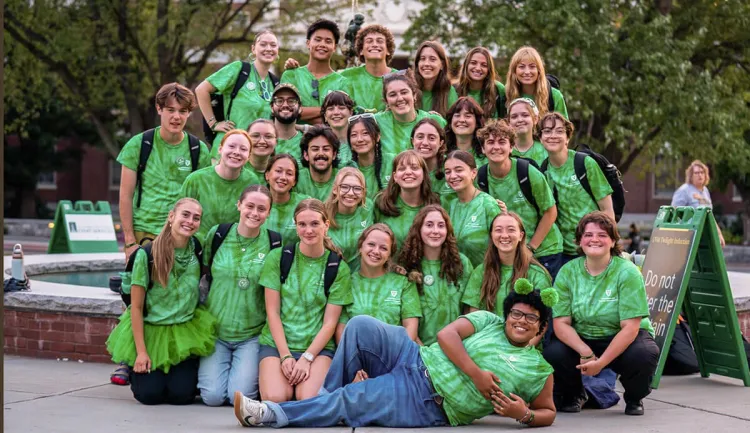 Student group posing together in front of of a fountain on UVM's campus