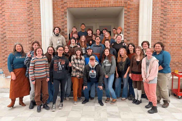 A large group of UVM students stand together, looking at the camera.