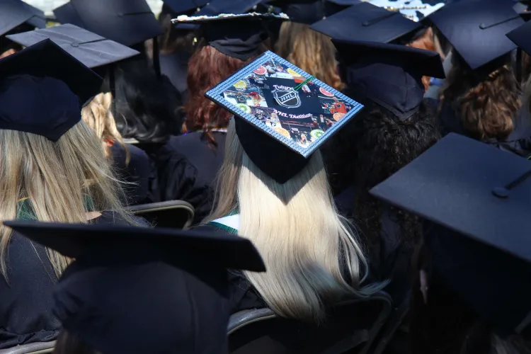 A photo from behind of graduation caps, including one decorated with photos and the words "future NHL dietician"