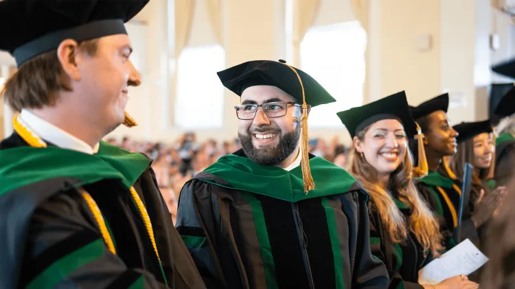 students wearing academic regalia at a ceremony