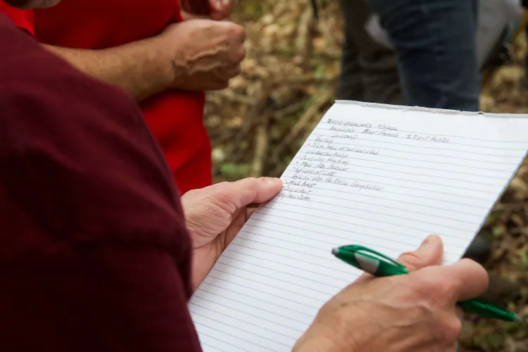 A picture of a person's hands holding a clipboard with writing on it.