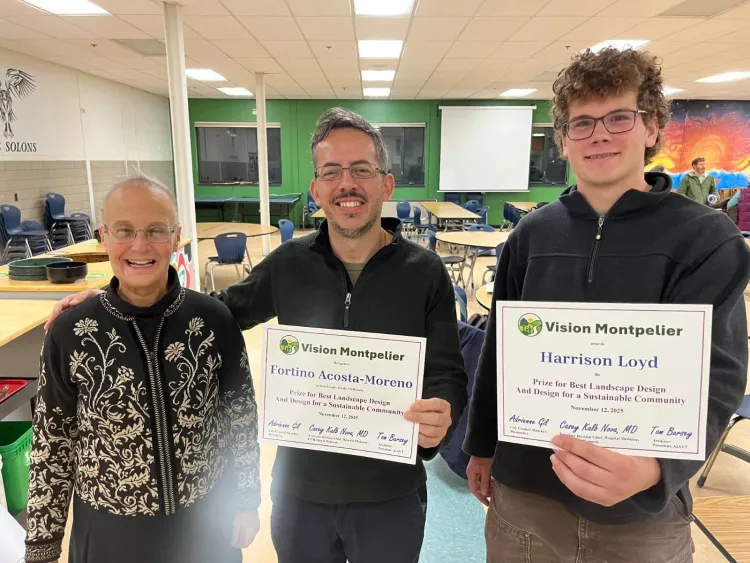 a woman and two men with award certificates