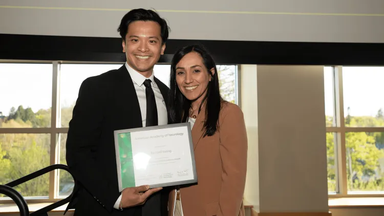 2 people posing with an award certificate
