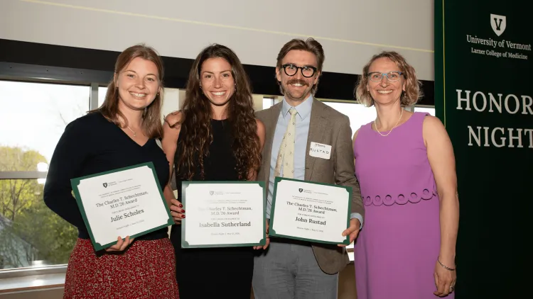 4 people posing with award certificates near an Honors Night banner