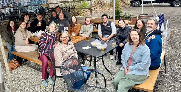 Group of people sit around tables on a patio