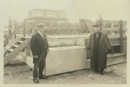vintage sepia toned photo of two men at a building cornerstone