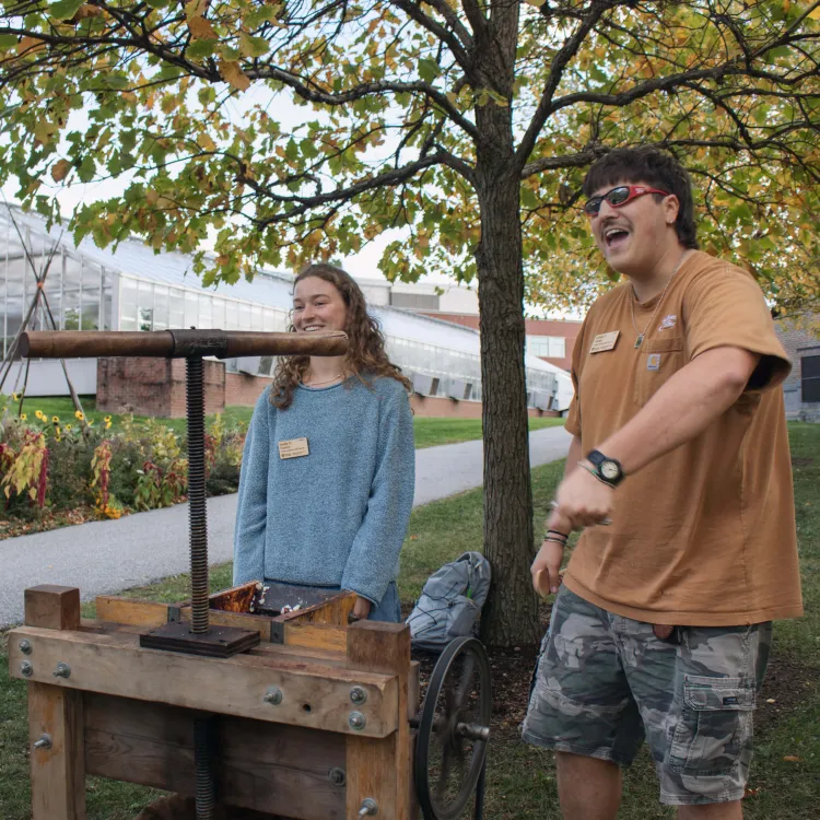 Carlos and Stella standing by the apple press at Ciderbration.