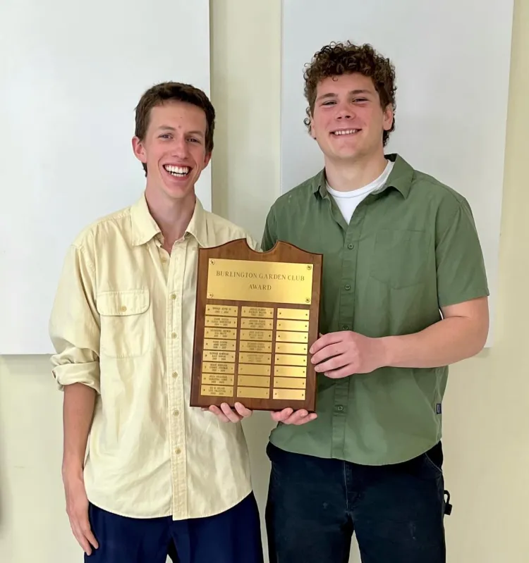 Two young men holding an award plaque