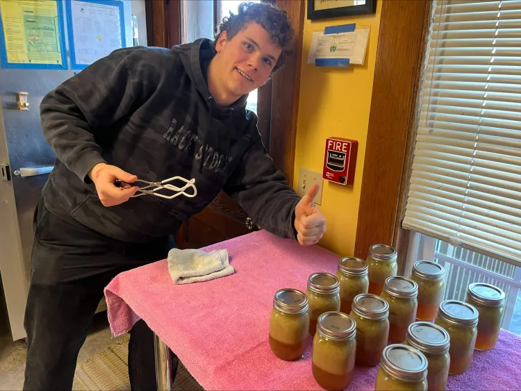A man leaning over some canned jar