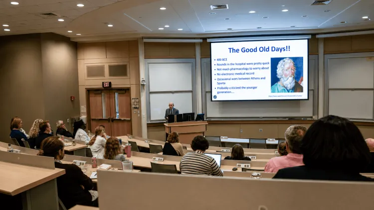 a person presenting a lecture in a large classroom